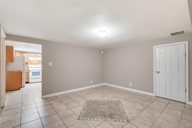 3216 Revere St, Aurora, CO 80011 - empty room featuring light tile patterned flooring and baseboards