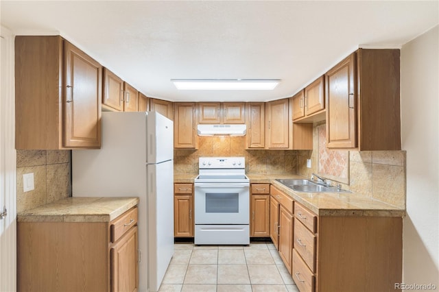 3216 Revere St, Aurora, CO 80011 - kitchen featuring white appliances, under cabinet range hood, a sink, backsplash, and light tile patterned flooring