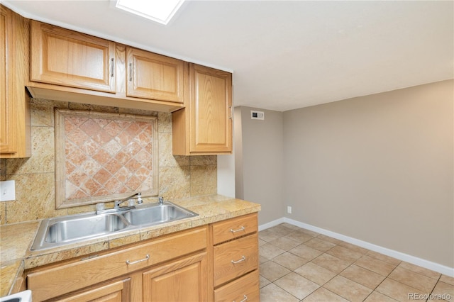 3216 Revere St, Aurora, CO 80011 - kitchen with a sink, baseboards, backsplash, light tile patterned floors, and tile countertops