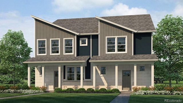 view of front of home with board and batten siding, a front yard, and roof with shingles