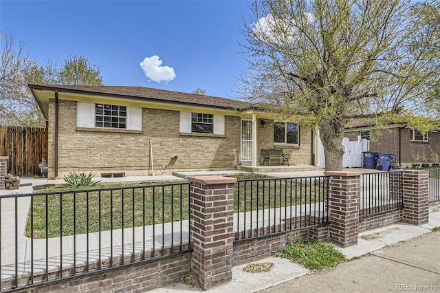 ranch-style house with a fenced front yard and brick siding