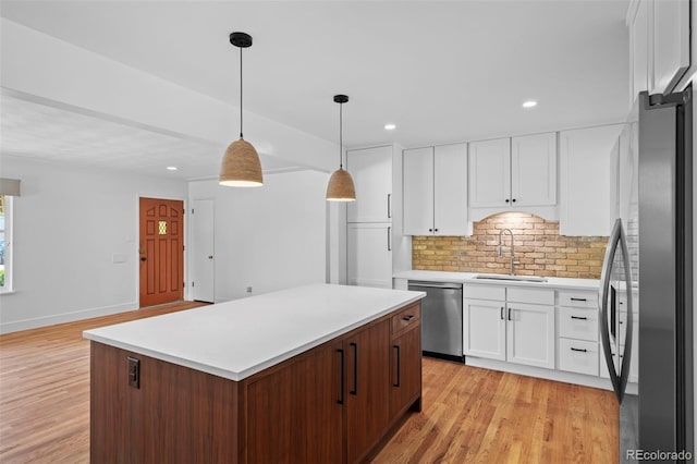 kitchen with a sink, stainless steel appliances, light wood-type flooring, backsplash, and recessed lighting
