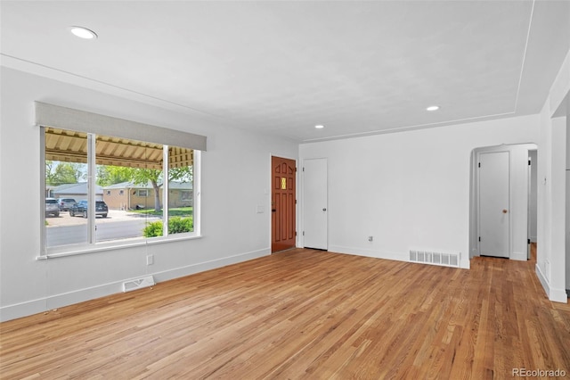 spare room featuring light wood finished floors, baseboards, and recessed lighting