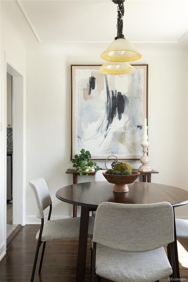dining area featuring baseboards and dark wood-style flooring