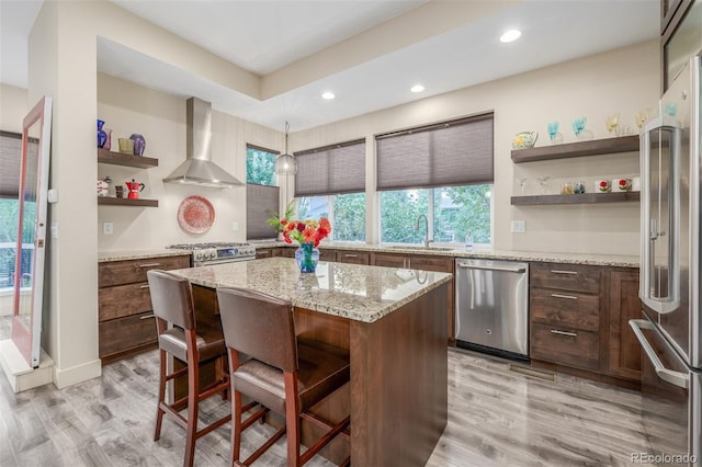 6761 Alan Dr, Denver, CO 80221 - kitchen with appliances with stainless steel finishes, wall chimney range hood, open shelves, healthy amount of natural light, and recessed lighting