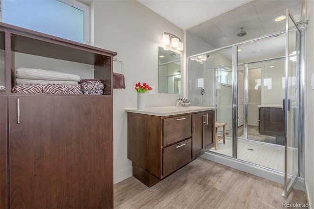 6761 Alan Dr, Denver, CO 80221 - bathroom featuring wood finished floors, a shower stall, and vanity