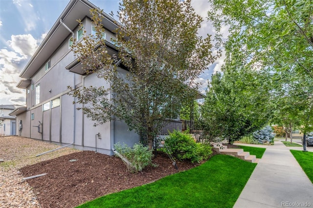 6761 Alan Dr, Denver, CO 80221 - view of side of home featuring stucco siding and a yard