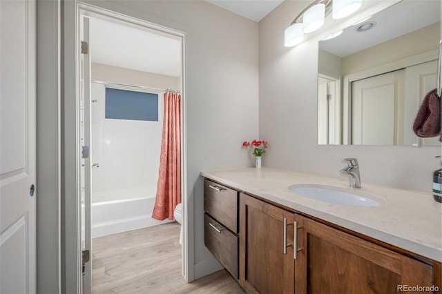 6761 Alan Dr, Denver, CO 80221 - full bath with vanity, wood finished floors, and shower / bath combo