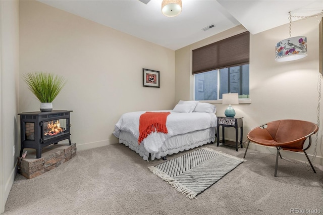 6761 Alan Dr, Denver, CO 80221 - carpeted bedroom with baseboards and a wood stove