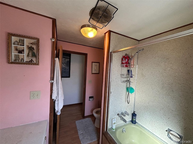 bathroom with hardwood / wood-style flooring, ornamental molding, toilet, and washtub / shower combination