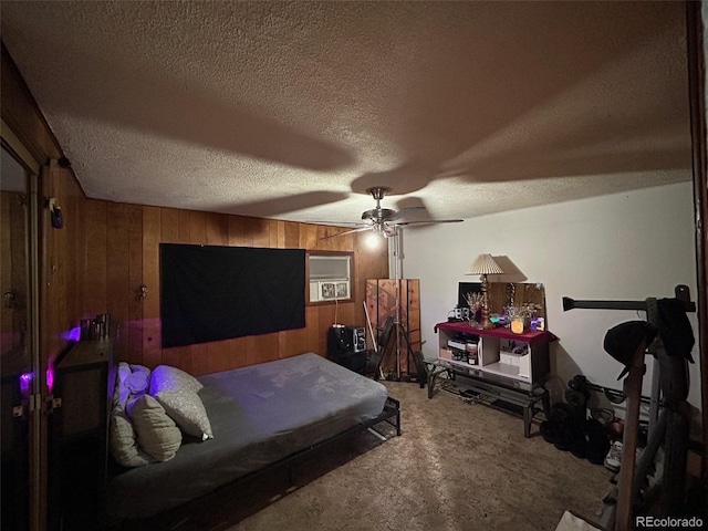 carpeted bedroom with a textured ceiling, ceiling fan, and wood walls