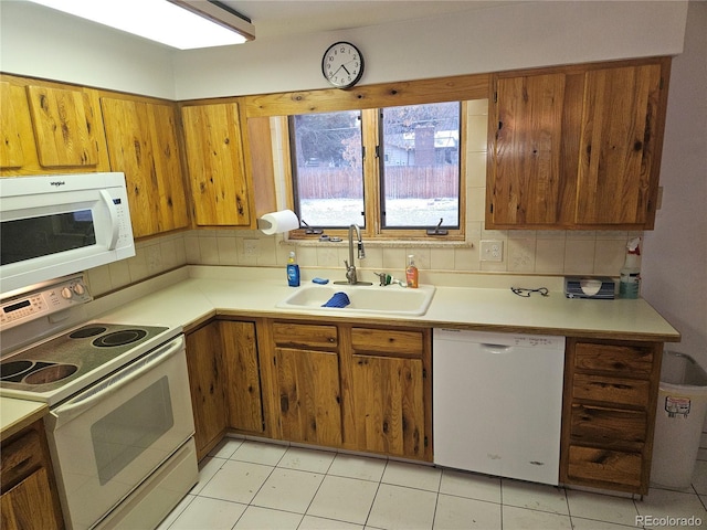 kitchen with sink, white appliances, backsplash, and light tile patterned floors