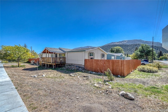 view of side of property with a deck with mountain view