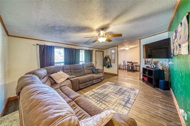 living room featuring ornamental molding, wood-type flooring, ceiling fan, and a textured ceiling