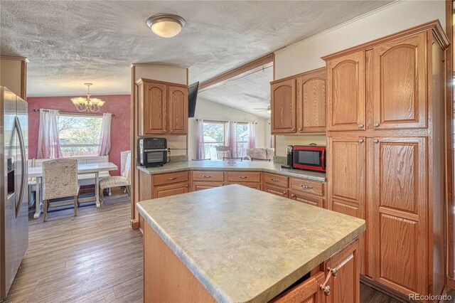 205 Sabeta Ave, Poncha Springs, CO 81242 - kitchen featuring stainless steel fridge, a chandelier, a textured ceiling, vaulted ceiling, and light countertops