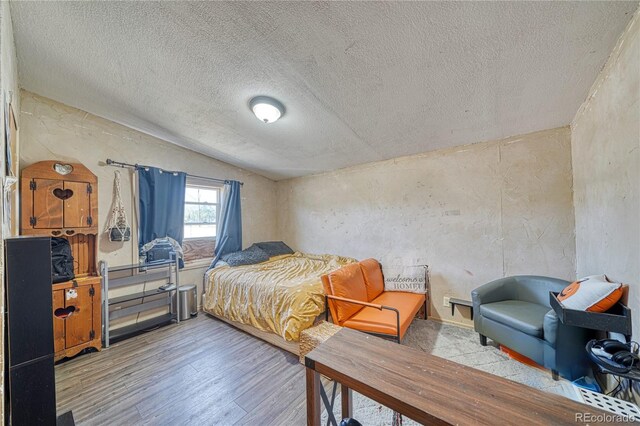 205 Sabeta Ave, Poncha Springs, CO 81242 - bedroom featuring lofted ceiling, wood finished floors, and a textured ceiling