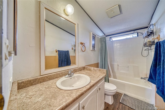 full bathroom featuring vanity, wood-type flooring, a textured ceiling, shower / bath combo with shower curtain, and toilet