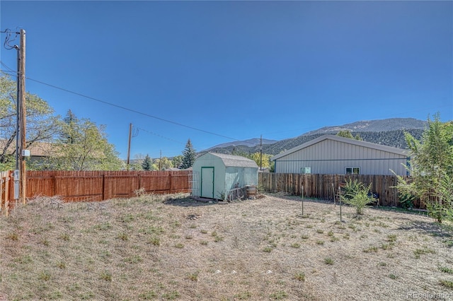 view of yard with a storage shed and a mountain view