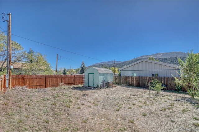 205 Sabeta Ave, Poncha Springs, CO 81242 - fenced backyard featuring a storage shed, a mountain view, and an outbuilding