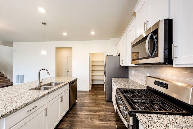 13376 Willow St, Thornton, CO 80602 - kitchen with appliances with stainless steel finishes, white cabinetry, dark wood-style flooring, decorative backsplash, and recessed lighting