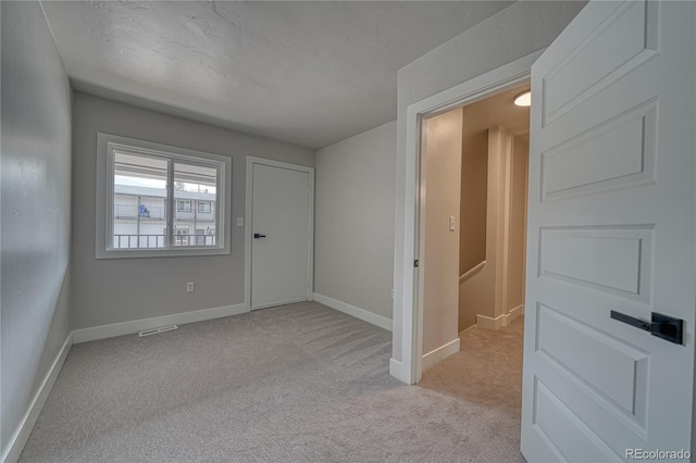 foyer entrance featuring light carpet