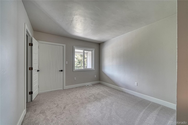 unfurnished room featuring light colored carpet