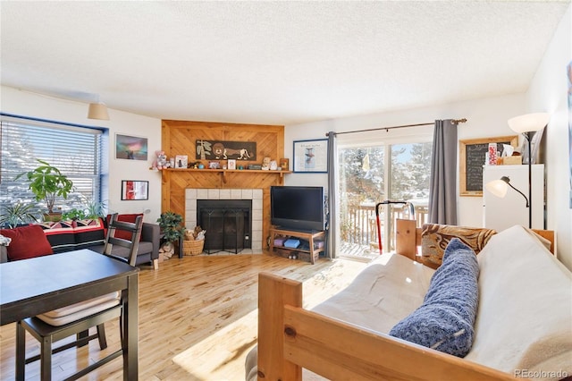 living room with a textured ceiling, a fireplace, and hardwood / wood-style flooring