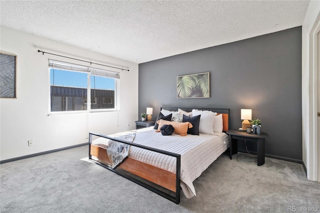 bedroom with carpet floors, baseboards, and a textured ceiling