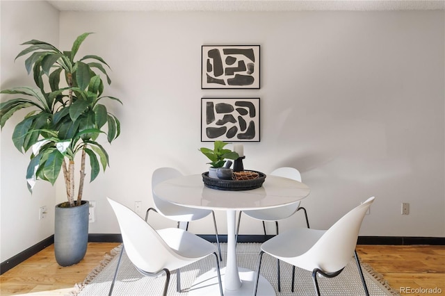 dining room with baseboards and wood finished floors