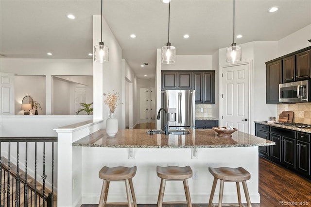 4011 W 149th Ave, Broomfield, CO 80023 - kitchen with stainless steel appliances, light stone countertops, a kitchen bar, tasteful backsplash, and recessed lighting