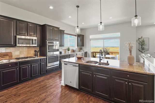 4011 W 149th Ave, Broomfield, CO 80023 - kitchen featuring appliances with stainless steel finishes, tasteful backsplash, recessed lighting, light stone counters, and dark wood-style floors
