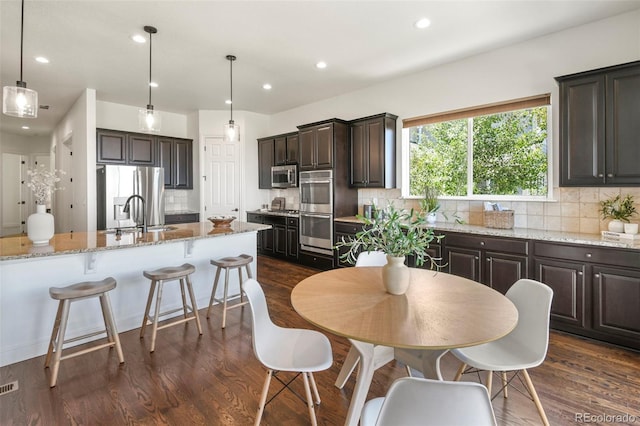 4011 W 149th Ave, Broomfield, CO 80023 - kitchen featuring appliances with stainless steel finishes, dark wood-style flooring, decorative backsplash, dark brown cabinets, and recessed lighting