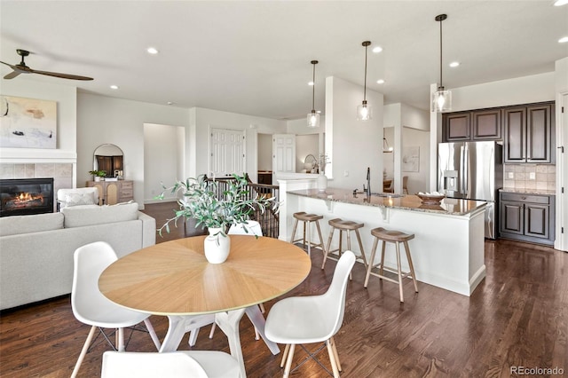 4011 W 149th Ave, Broomfield, CO 80023 - dining room with ceiling fan, dark wood-type flooring, a tiled fireplace, and recessed lighting