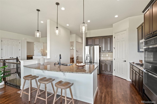 4011 W 149th Ave, Broomfield, CO 80023 - kitchen with stainless steel appliances, dark brown cabinets, light stone countertops, dark wood-style floors, and recessed lighting
