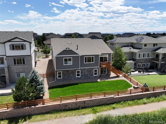 4011 W 149th Ave, Broomfield, CO 80023 - rear view of house featuring a residential view, stairs, stone siding, and a fenced backyard