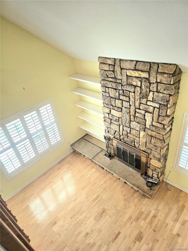 13304 E Asbury Dr, Aurora, CO 80014 - unfurnished living room with wood finished floors, baseboards, and a stone fireplace
