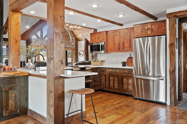 700 Cottage Grove Rd, Alma, CO 80420 - kitchen featuring stainless steel appliances, light wood-style floors, light countertops, tasteful backsplash, and a peninsula