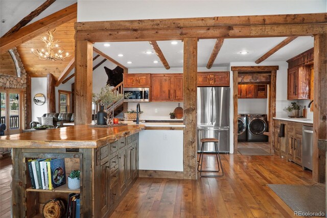 700 Cottage Grove Rd, Alma, CO 80420 - kitchen featuring stainless steel appliances, separate washer and dryer, beamed ceiling, hardwood / wood-style flooring, and open shelves