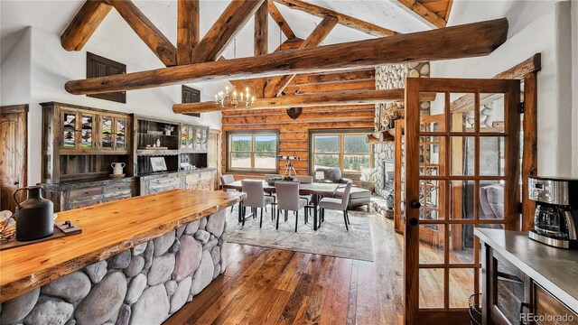 700 Cottage Grove Rd, Alma, CO 80420 - dining space featuring dark wood finished floors, beamed ceiling, log walls, a chandelier, and high vaulted ceiling