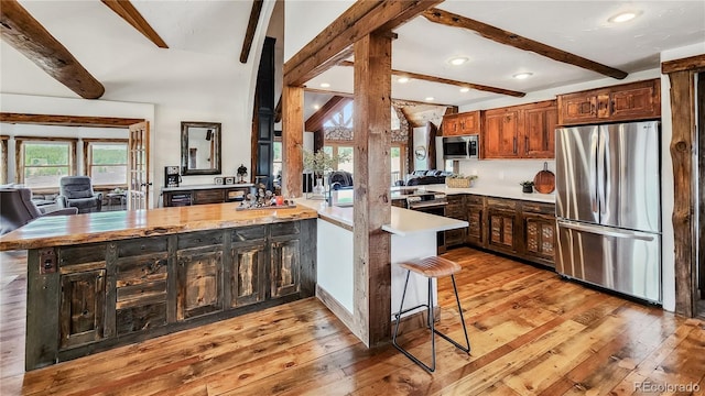700 Cottage Grove Rd, Alma, CO 80420 - kitchen featuring stainless steel appliances, a peninsula, beam ceiling, light wood-style flooring, and light countertops