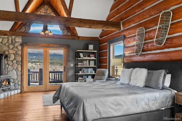 700 Cottage Grove Rd, Alma, CO 80420 - bedroom featuring log walls, hardwood / wood-style flooring, a wood stove, and access to exterior