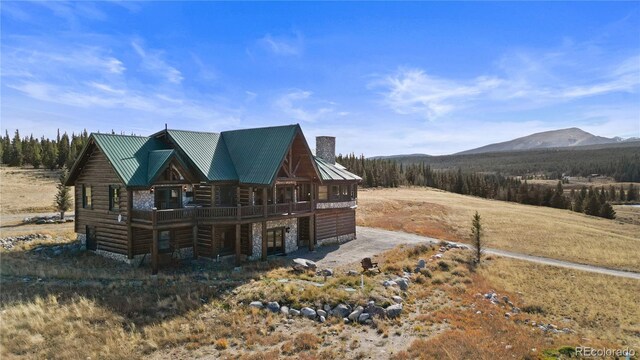 700 Cottage Grove Rd, Alma, CO 80420 - back of house featuring a chimney, metal roof, stone siding, and a deck with mountain view