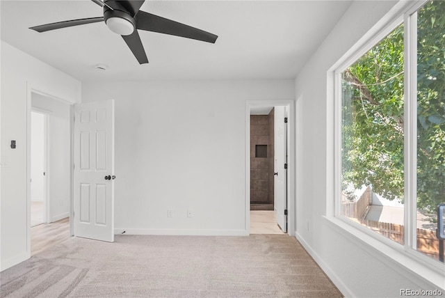 empty room with light carpet, a healthy amount of sunlight, and ceiling fan