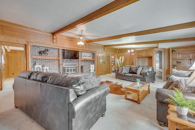 carpeted living room with beam ceiling, wooden walls, and ceiling fan