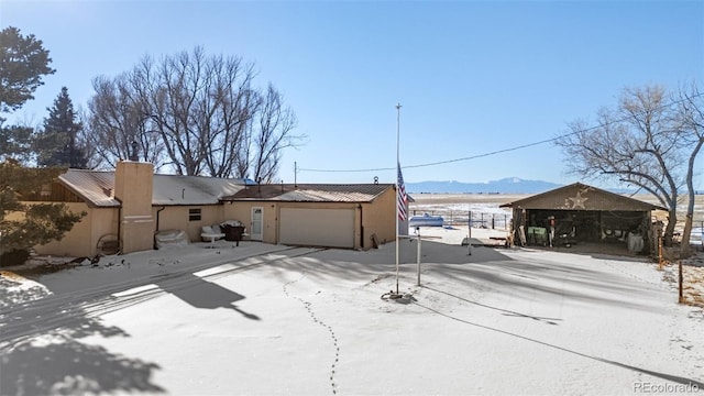 exterior space with a garage, a mountain view, and a carport