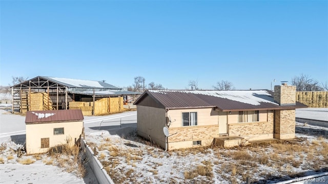 view of snowy exterior with a storage unit