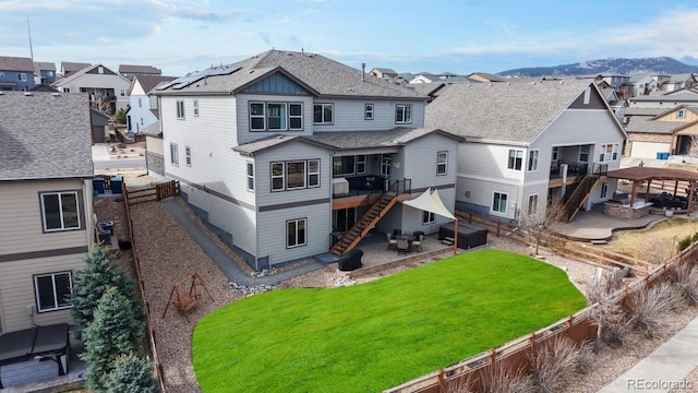 18541 W 93rd Pl, Arvada, CO 80007 - rear view of property featuring a residential view, stairway, a patio area, a deck with mountain view, and a jacuzzi