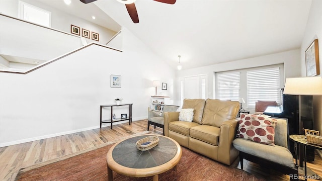 living room featuring wood-type flooring, ceiling fan, and high vaulted ceiling