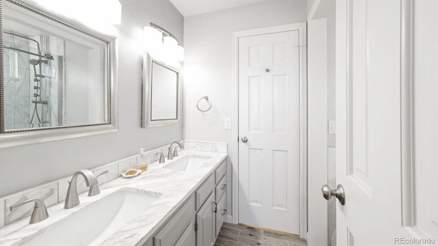 bathroom with walk in shower, vanity, and hardwood / wood-style floors