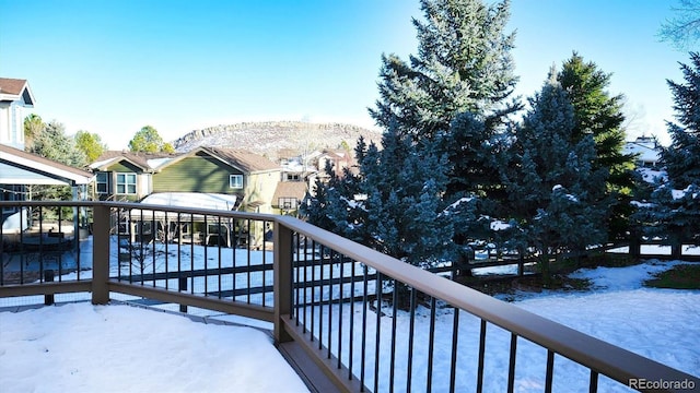 snow covered back of property with a mountain view